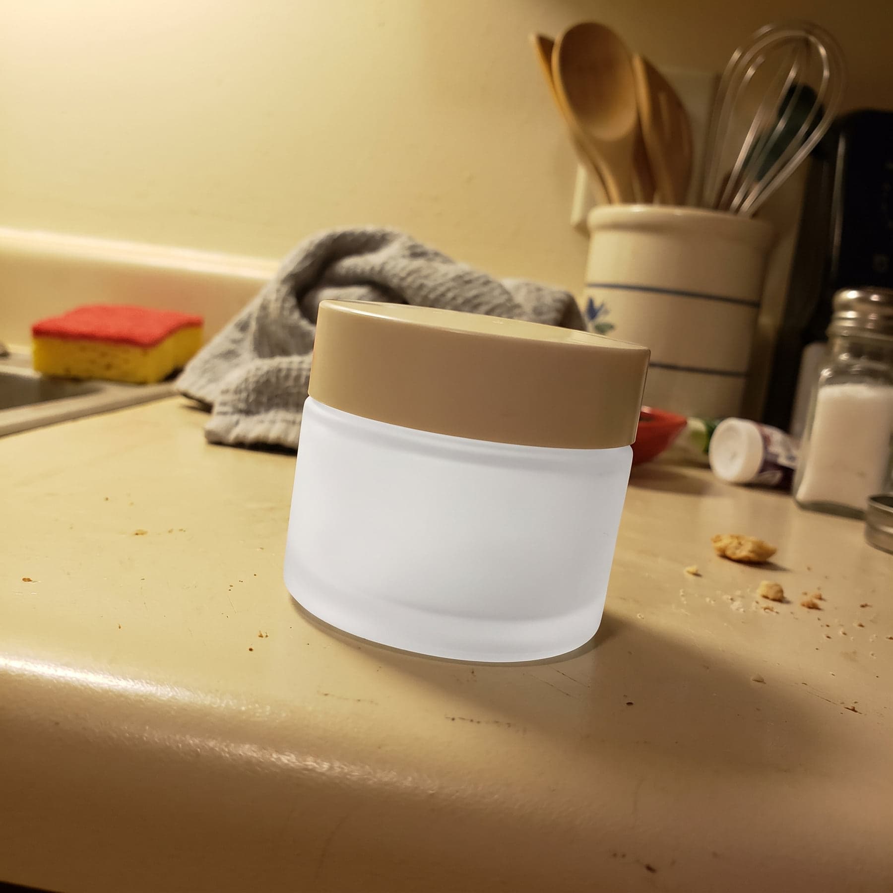 A skincare jar shot on a kitchen counter with a phone, and the same product styled on a marble shelf
